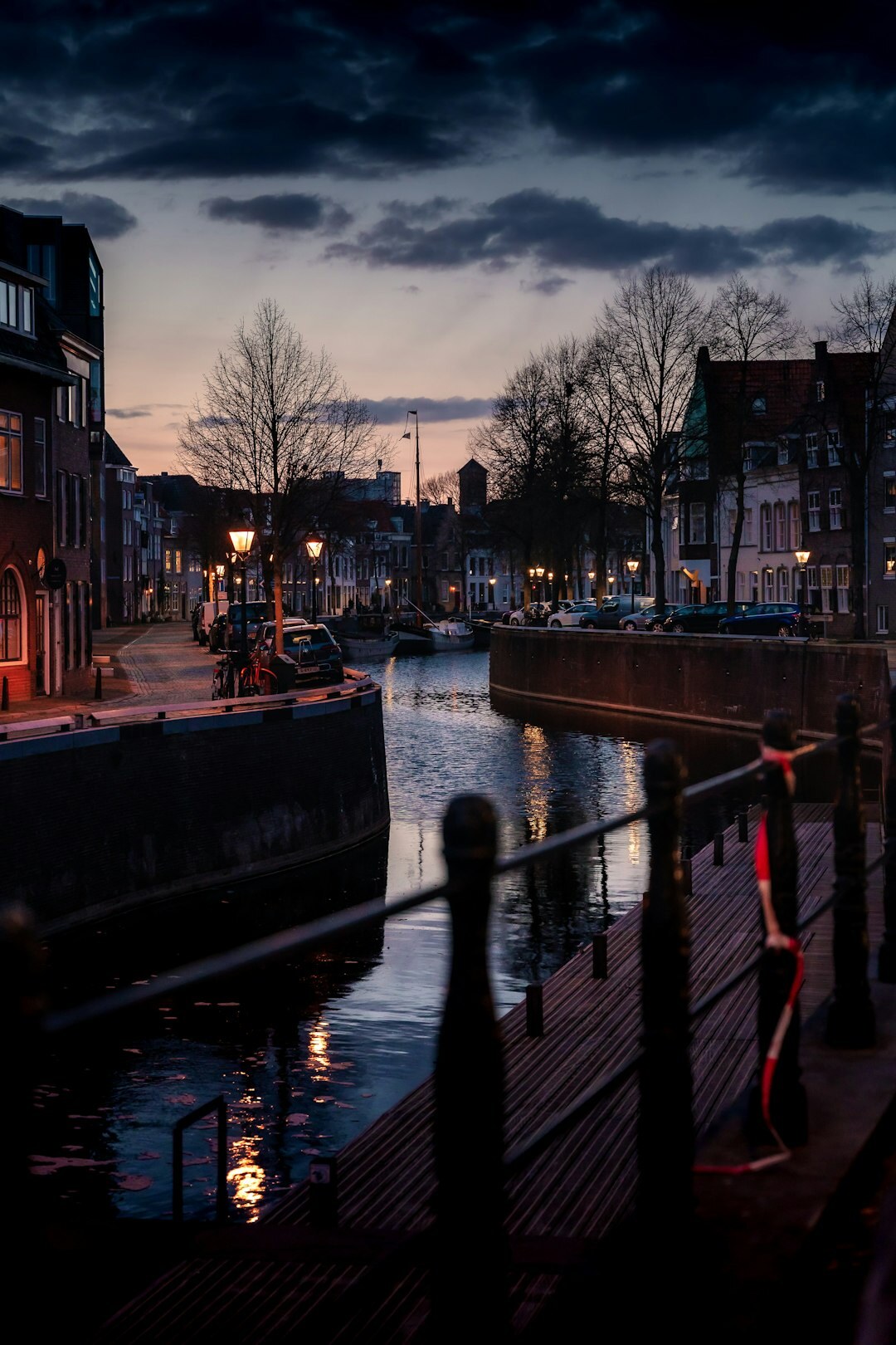 Illustrated detective book cover showing Dutch canal houses at dusk with a shadowy figure