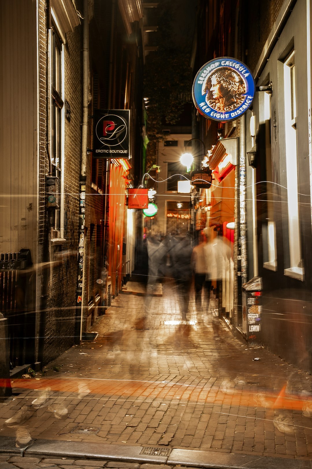 Rainy narrow Amsterdam alley at night with a single streetlamp